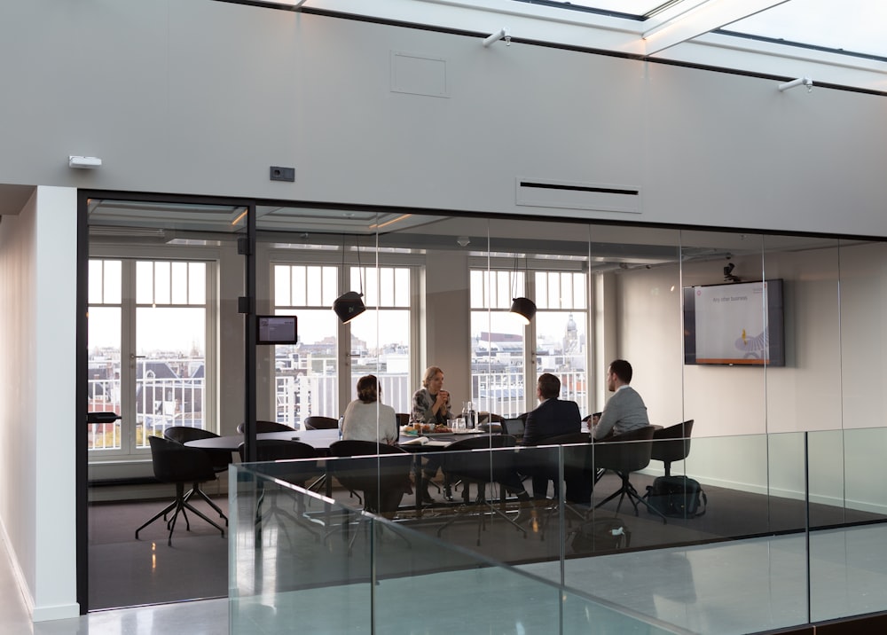 Wide shot of a conference room with minimalist design and a large window overlooking a cityscape.