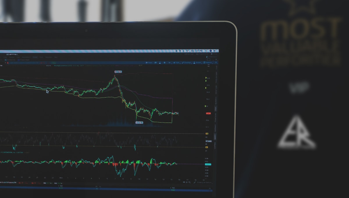 A clean, minimalist workspace with financial charts and a laptop displaying global wealth data.