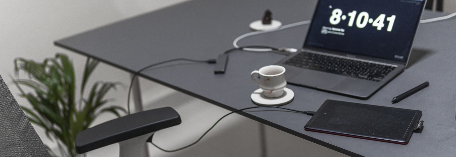 A minimalist workspace with a sleek laptop and a cup of coffee on a clean desk.